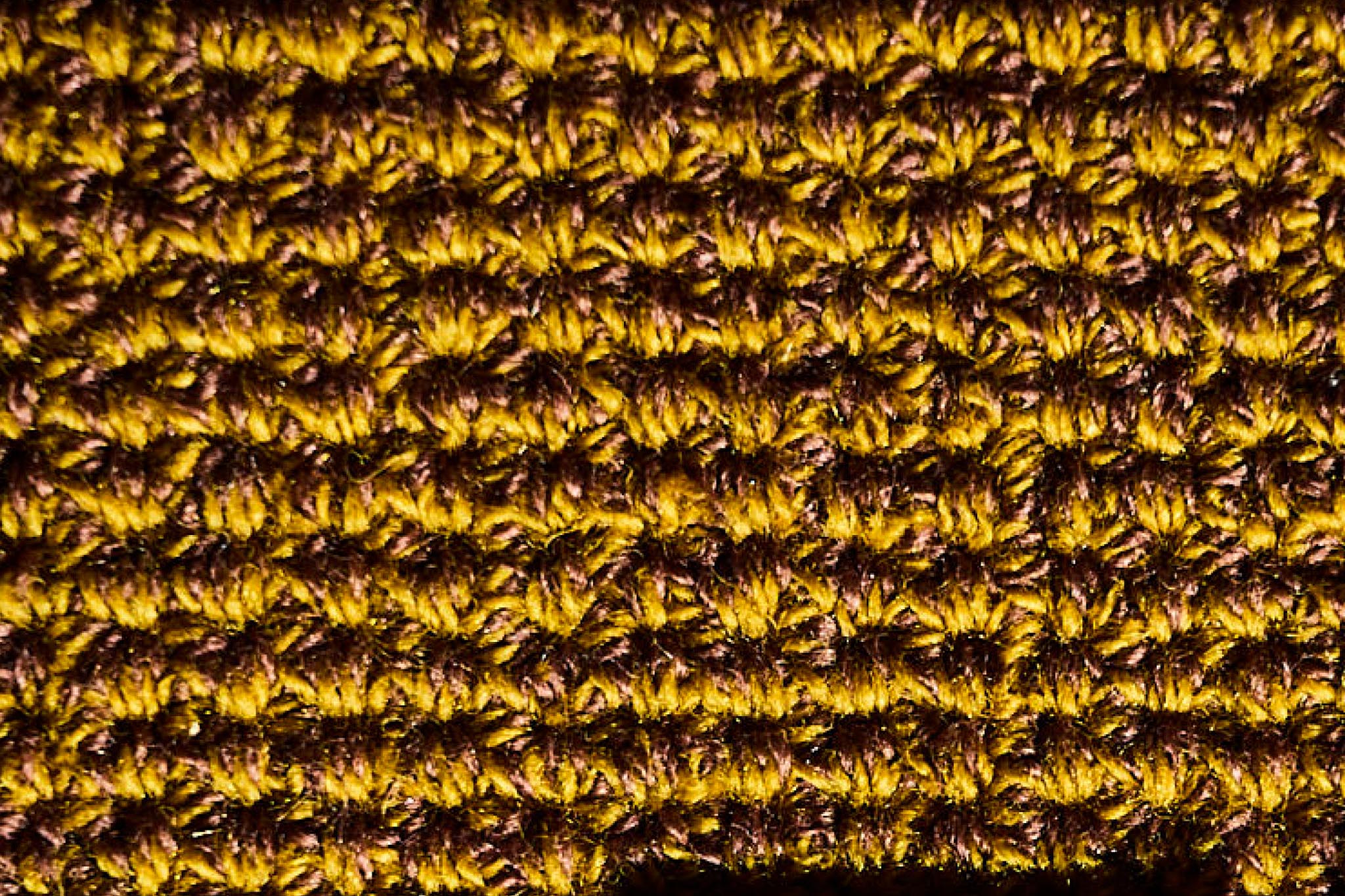 Nahaufnahme eines gestrickten Stoffmusters in Gelb und Braun